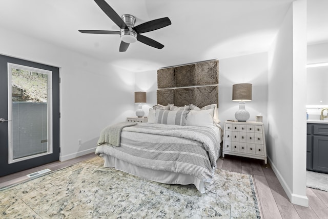 bedroom with visible vents, baseboards, a ceiling fan, and wood finished floors