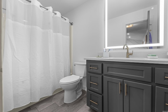 bathroom featuring toilet, vanity, and wood finished floors