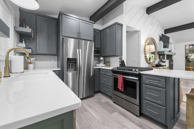 kitchen with open shelves, a peninsula, light countertops, and appliances with stainless steel finishes