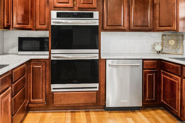 2312 Breckenridge Dr, Little Rock, AR 72227 - kitchen with light stone counters, light wood finished floors, appliances with stainless steel finishes, and decorative backsplash
