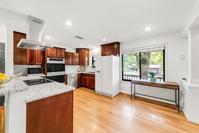 2312 Breckenridge Dr, Little Rock, AR 72227 - kitchen with tasteful backsplash, island range hood, stainless steel appliances, light wood finished floors, and visible vents