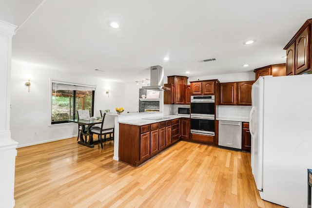 2312 Breckenridge Dr, Little Rock, AR 72227 - kitchen with stainless steel appliances, a peninsula, island exhaust hood, and ornate columns