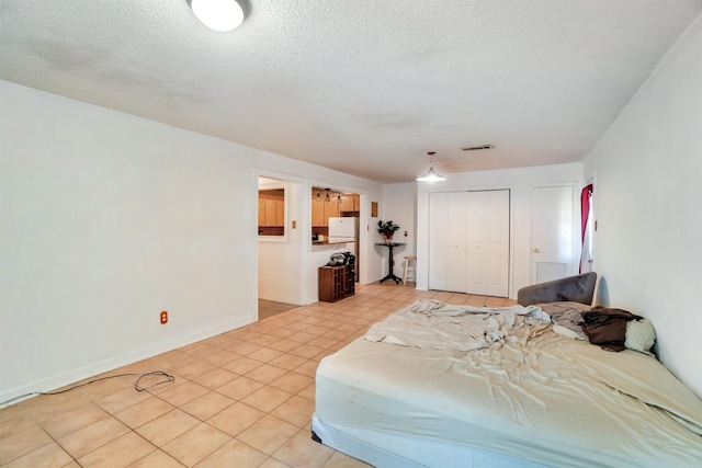 5907 Jacksonville Conway Rd, Jacksonville, AR 72076 - bedroom with a closet, light tile patterned floors, baseboards, visible vents, and freestanding refrigerator