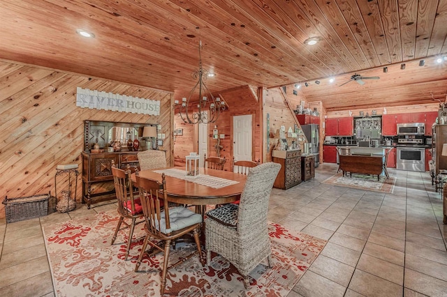 dining room featuring ceiling fan with notable chandelier, wooden ceiling, wood walls, and light tile patterned flooring