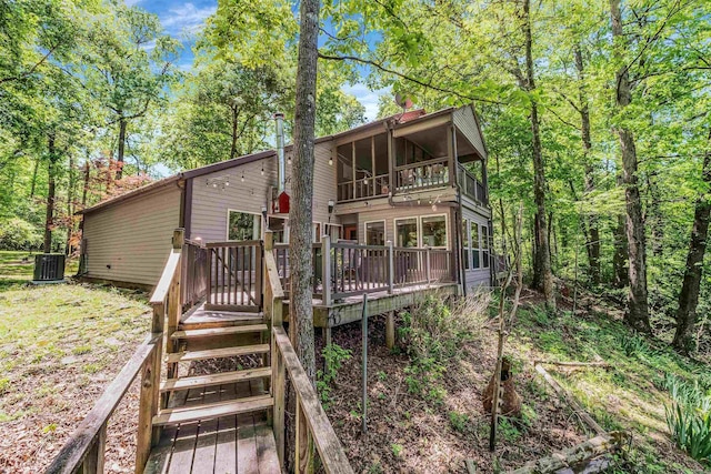 back of house featuring a chimney, a balcony, central AC, and a deck
