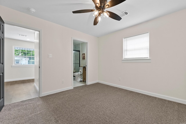unfurnished bedroom with baseboards, visible vents, carpet floors, and connected bathroom