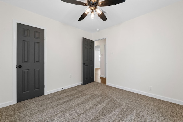 unfurnished bedroom with a ceiling fan, carpet flooring, and baseboards