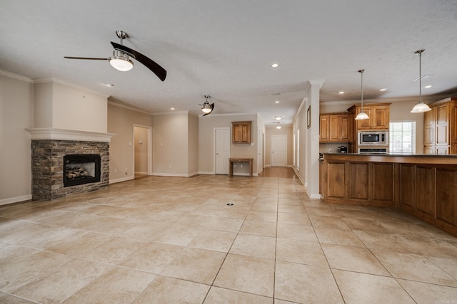 505 Fieldstone, Conway, AR 72034 - kitchen with crown molding, stainless steel microwave, brown cabinetry, and a stone fireplace