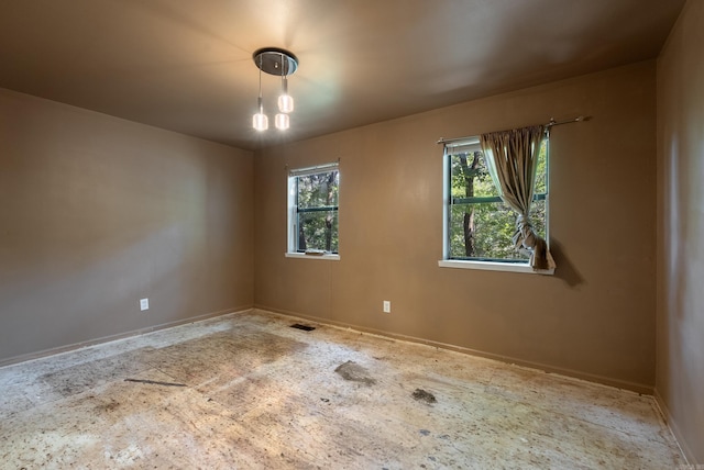 unfurnished room with visible vents and baseboards