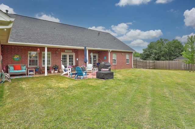 rear view of house featuring roof with shingles, fence, french doors, and brick siding
