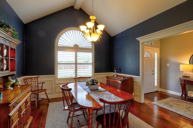 dining room featuring dark wood-type flooring, a wainscoted wall, and a notable chandelier