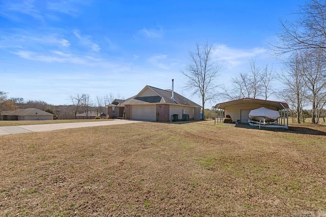 exterior space with a carport, driveway, an attached garage, and a front yard