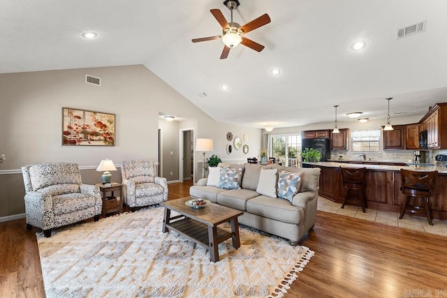 living room featuring visible vents, a ceiling fan, and light wood-style floors
