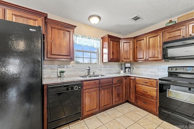 kitchen with decorative backsplash, light tile patterned floors, black appliances, a sink, and visible vents