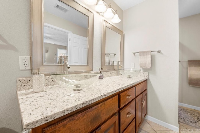 bathroom featuring visible vents, tile patterned flooring, double vanity, and a sink