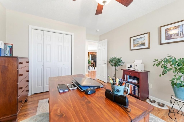 office space featuring ceiling fan, wood finished floors, and baseboards