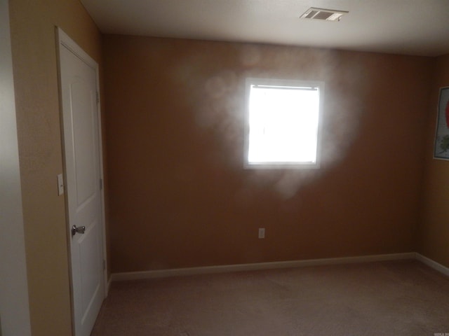 unfurnished room featuring visible vents, light carpet, and baseboards