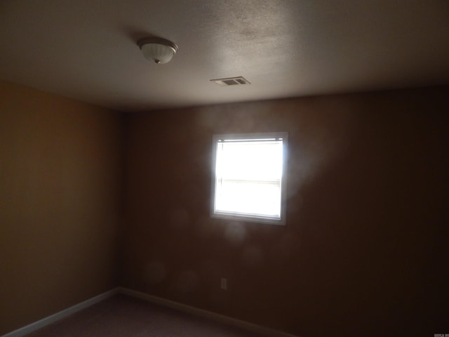 empty room featuring baseboards and visible vents