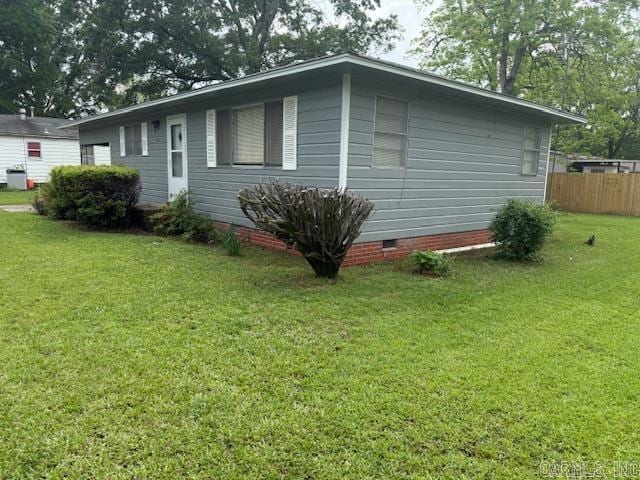 view of side of property with a lawn, crawl space, and fence