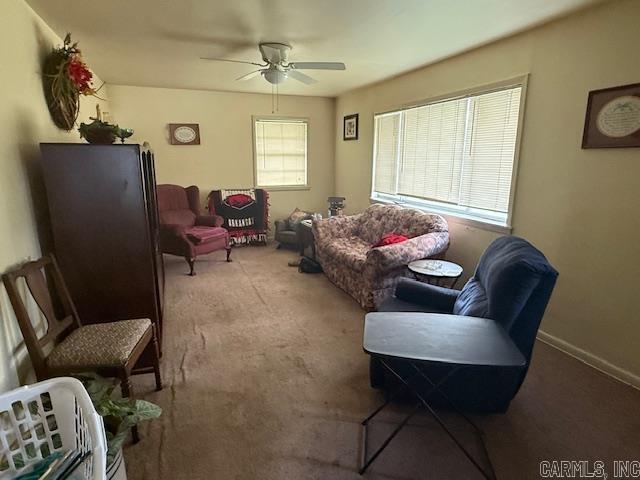 living room with a ceiling fan and carpet flooring