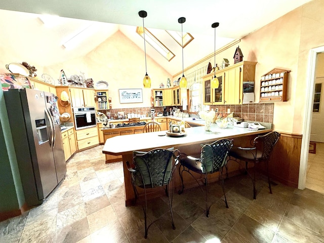 2157 Pleasant Grove Rd, Wideman, AR 72585 - kitchen featuring appliances with stainless steel finishes, hanging light fixtures, a peninsula, wainscoting, and backsplash