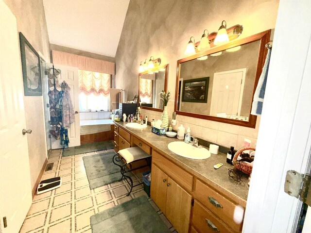 2157 Pleasant Grove Rd, Wideman, AR 72585 - bathroom featuring decorative backsplash, tile patterned floors, double vanity, a bath, and a sink