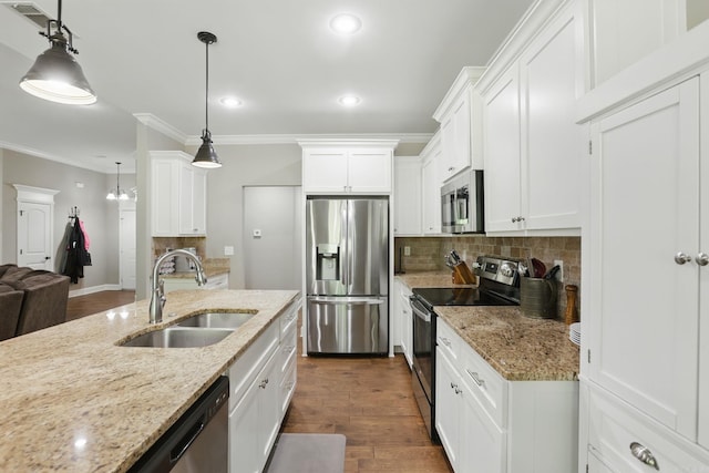 kitchen with white cabinetry, crown molding, a sink, stainless steel appliances, and backsplash