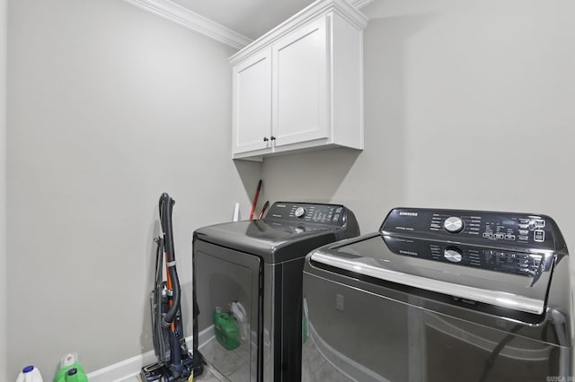 clothes washing area with ornamental molding, cabinet space, baseboards, and washer and clothes dryer
