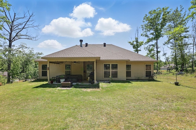 rear view of house featuring a patio, roof with shingles, a ceiling fan, and a lawn