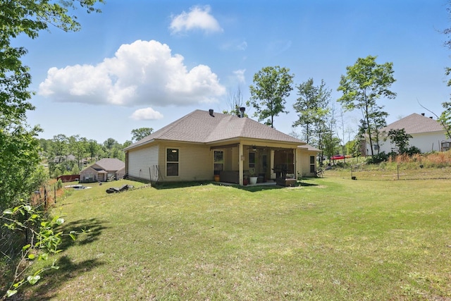 rear view of property with a lawn and a sunroom