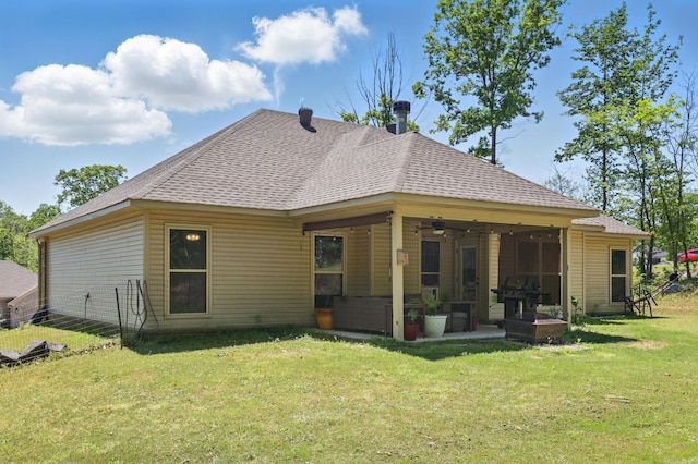 back of house featuring a ceiling fan, a yard, a patio area, and roof with shingles