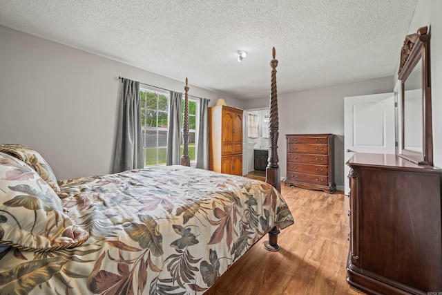 bedroom with a textured ceiling and light wood finished floors