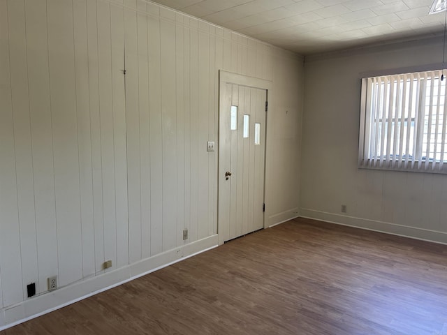 entrance foyer featuring wood walls, wood finished floors, and baseboards