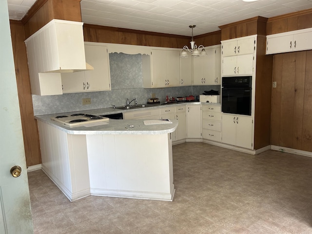 kitchen featuring white cooktop, black oven, a peninsula, and light floors