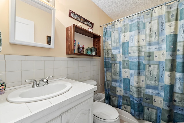 138 Ridge Rd, Houston, AR 72070 - bathroom with toilet, a textured ceiling, tile walls, and vanity