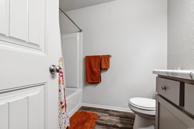 bathroom with vanity, toilet, shower / tub combo, baseboards, and wood finished floors