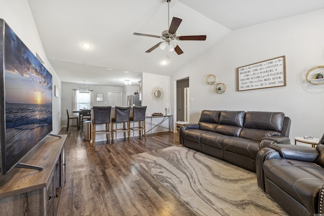 living area featuring dark wood-style flooring, recessed lighting, vaulted ceiling, and ceiling fan with notable chandelier