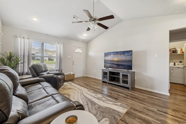 living area with wood finished floors, washer and dryer, visible vents, a ceiling fan, and lofted ceiling