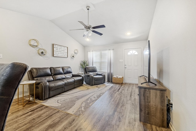 living area featuring wood finished floors, a ceiling fan, vaulted ceiling, and baseboards