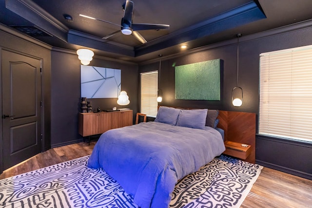 bedroom with visible vents, wood finished floors, ceiling fan, and ornamental molding