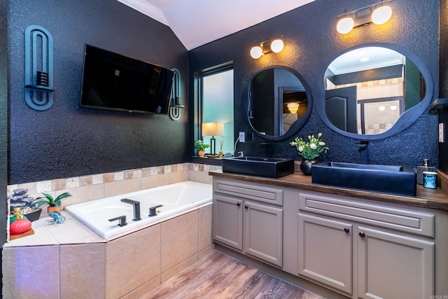 full bath featuring ornamental molding, a sink, a textured wall, and wood finished floors