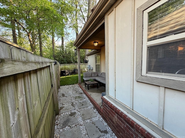 view of side of property with a patio, an outdoor hangout area, and a fenced backyard