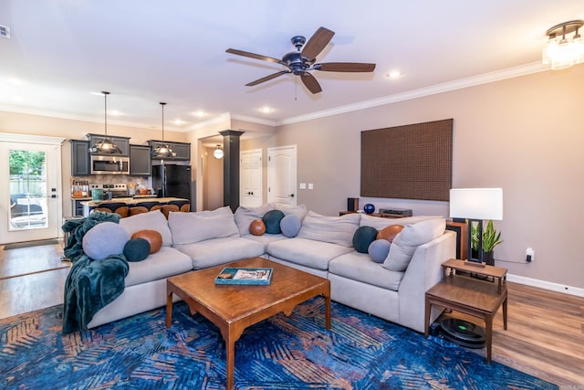 living area with recessed lighting, crown molding, a ceiling fan, baseboards, and wood finished floors
