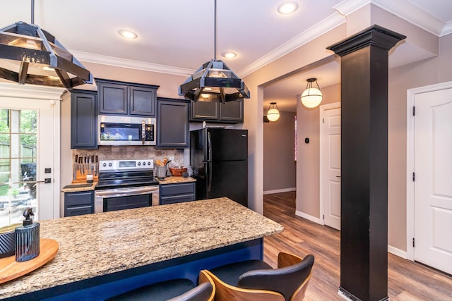 kitchen with appliances with stainless steel finishes, a kitchen bar, decorative backsplash, and baseboards
