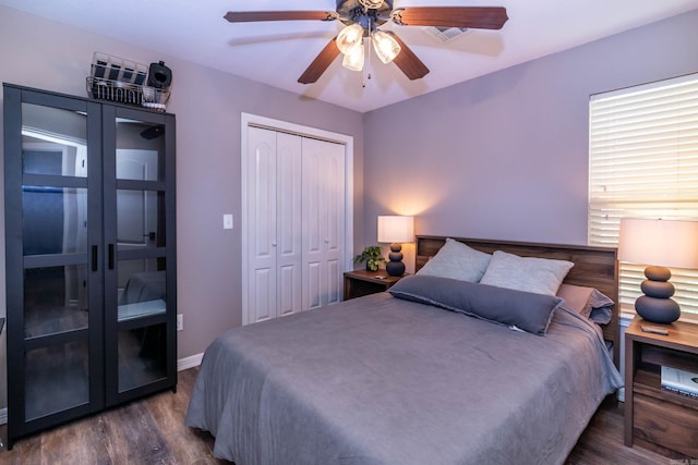 bedroom featuring dark wood-style floors, a closet, ceiling fan, and baseboards