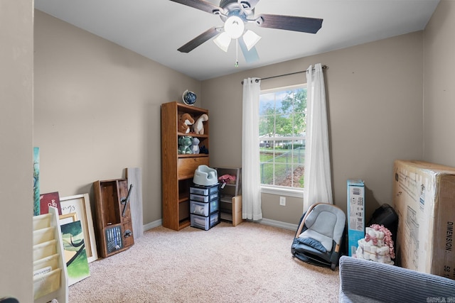sitting room featuring carpet, a ceiling fan, and baseboards