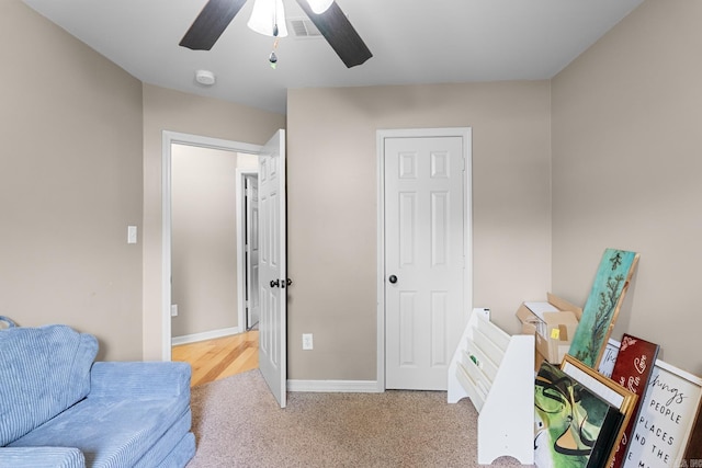 living area featuring visible vents, ceiling fan, baseboards, and carpet floors