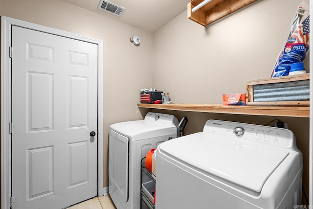 laundry area featuring visible vents, light tile patterned floors, separate washer and dryer, and laundry area