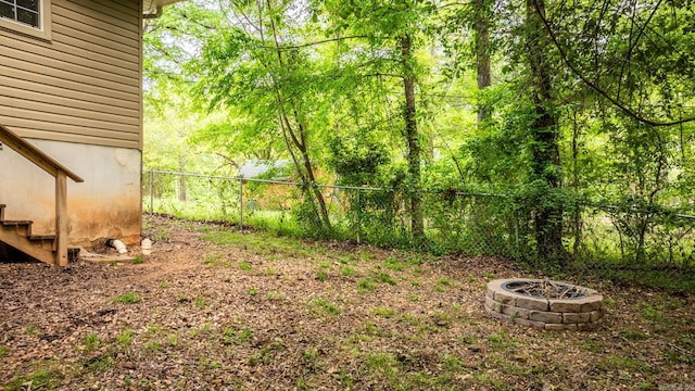 view of yard featuring fence and a fire pit