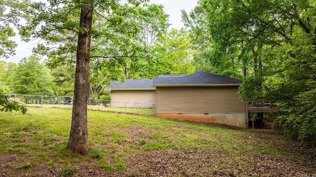 view of property exterior with a lawn, fence, a deck, and crawl space